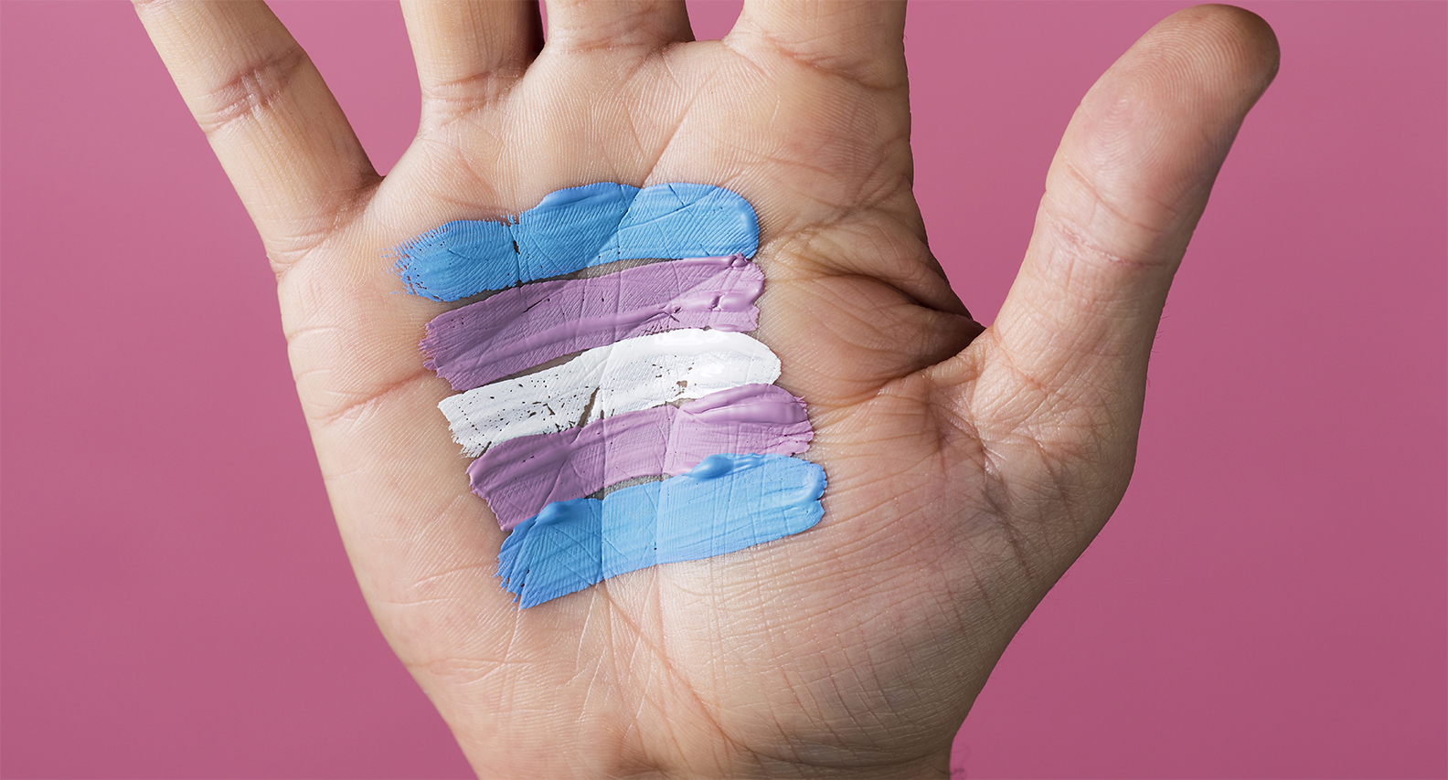 hand with the colors of the transgender flag painted on the palm