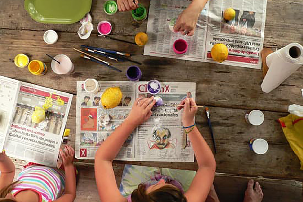 Youth making camp crafts with pain and newspaper