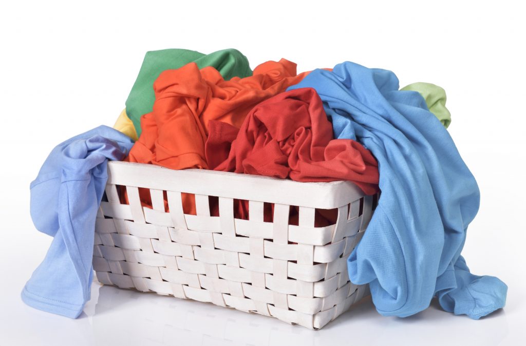Colorful dirty clothes in laundry basket isolated over white background
