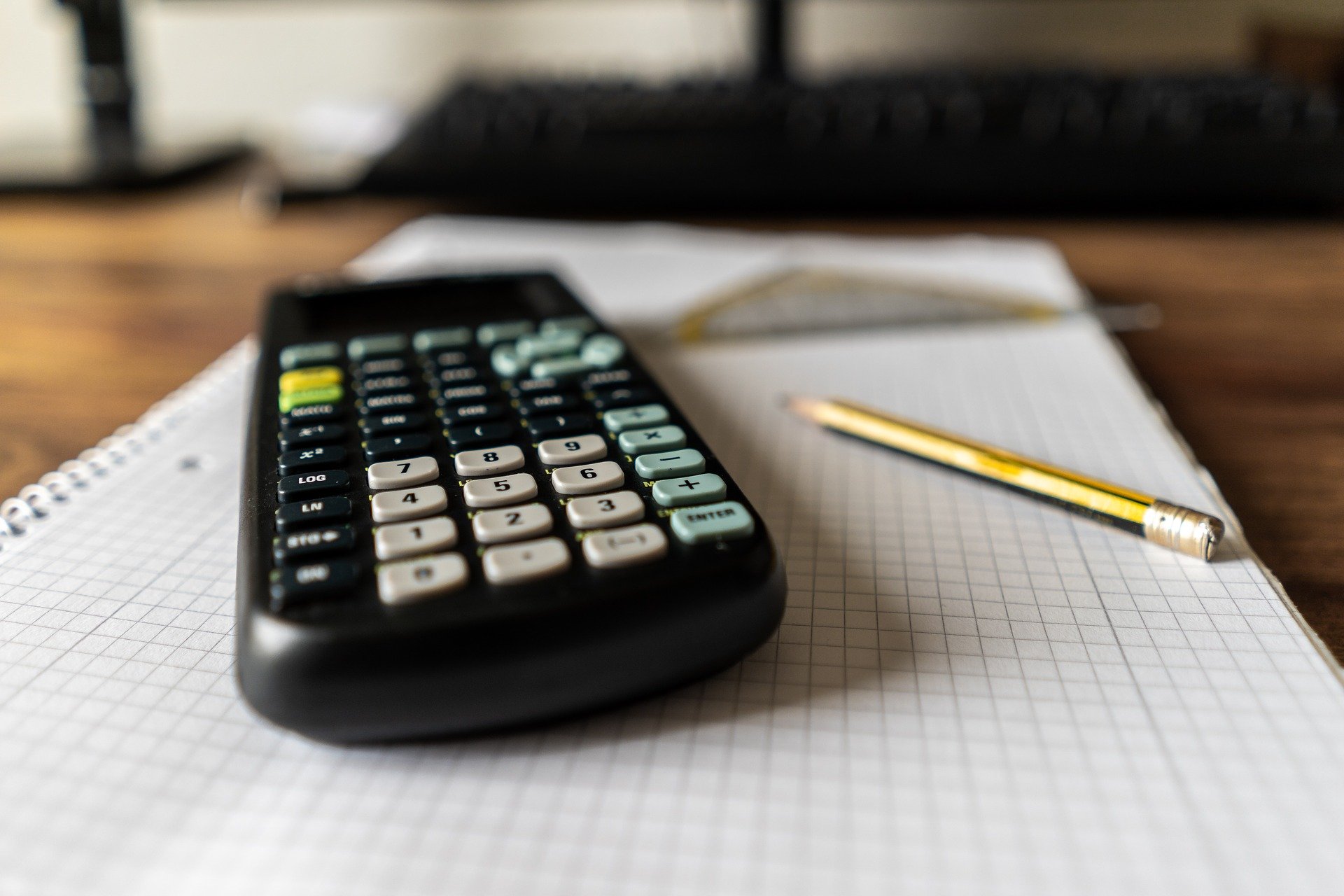 calculator and pencil sitting on desk