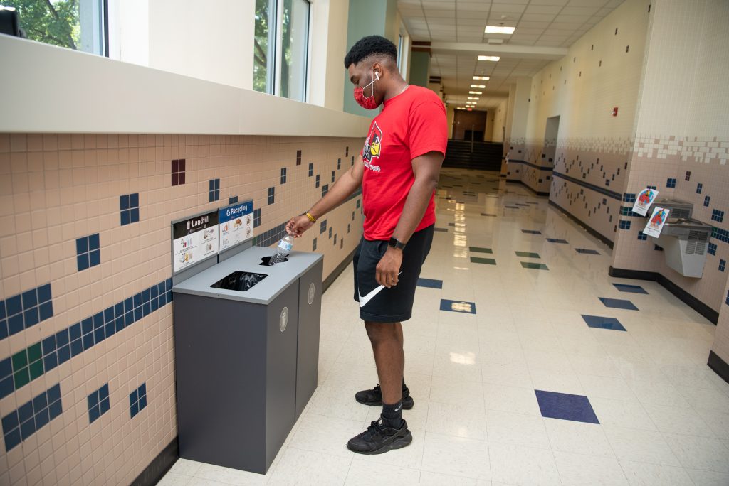 Male student places item in waste station