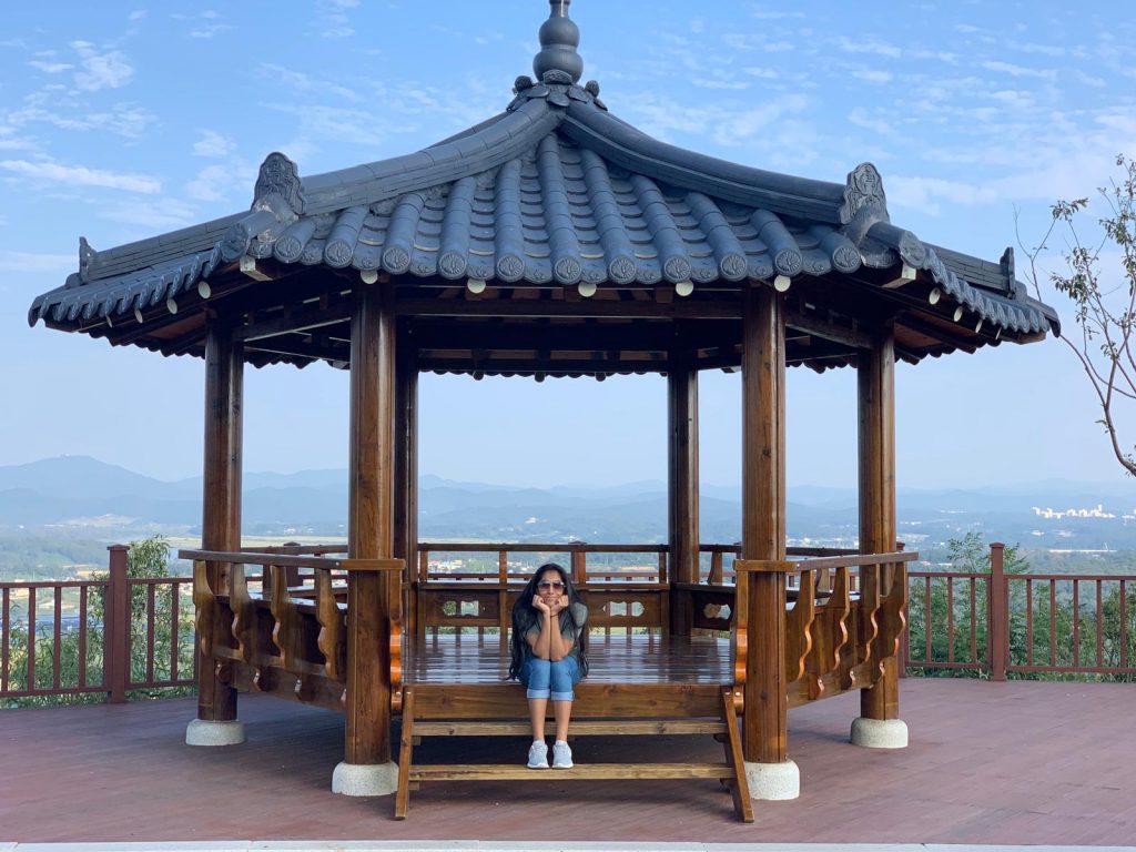 study abroad student sitting on the steps of a gazebo
