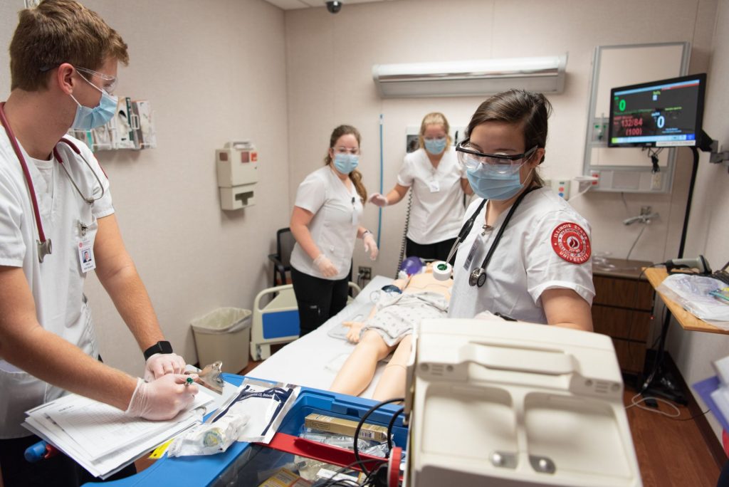 Students work in a nursing room simulation