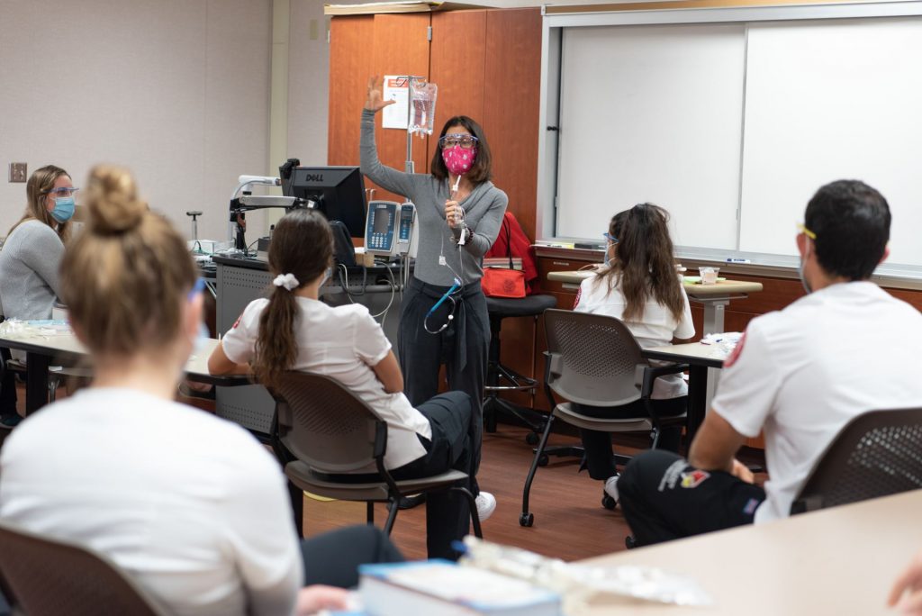 Professor demonstrates placing an IV to her students.