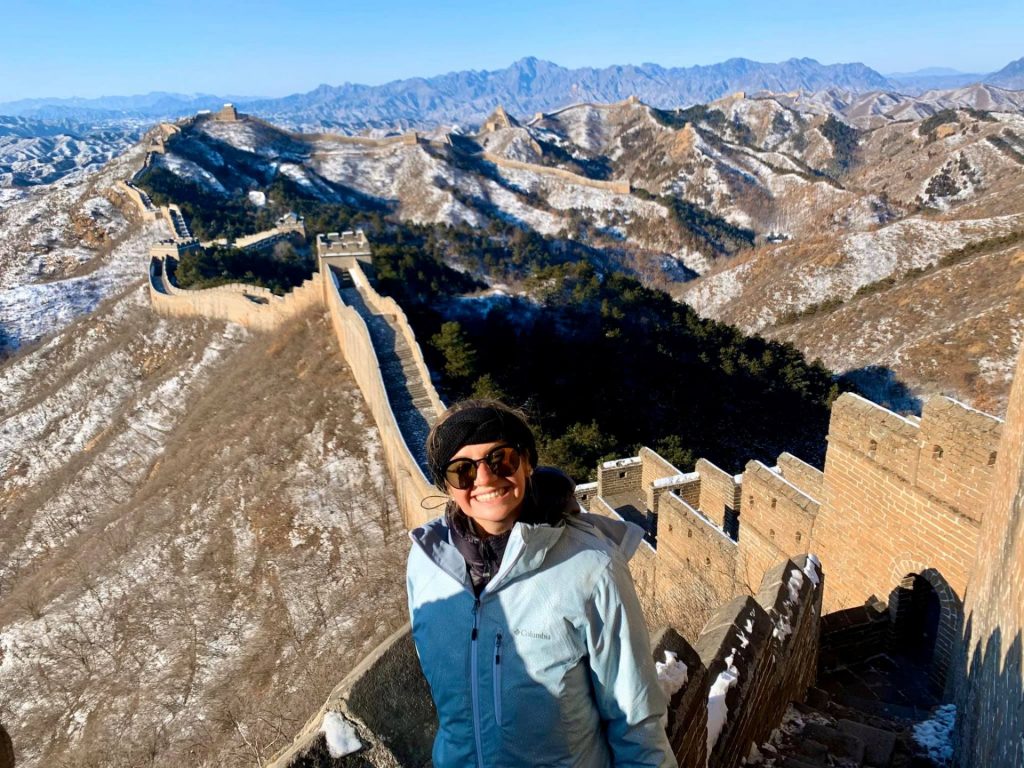 Study Abroad student poses in front of the Great Wall of China.