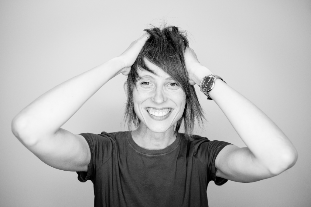 Woman smiling with hands on her head
