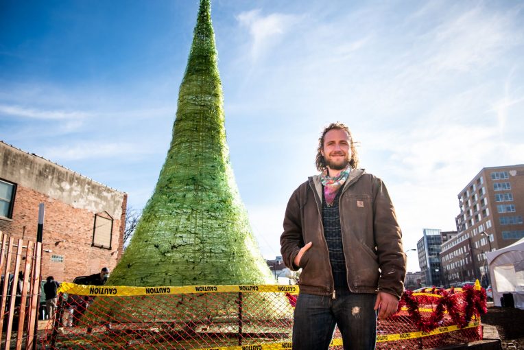 Alum and artist Jason Mack stands before his 31-foot glass Christmas tree.