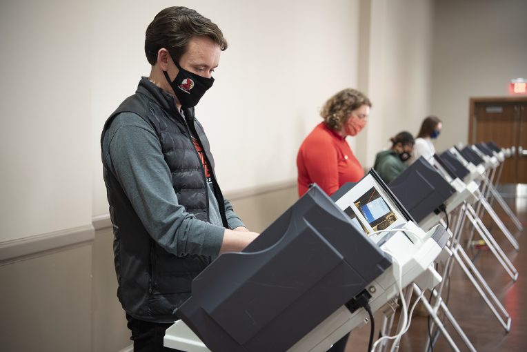 man and woman voting at a polling place