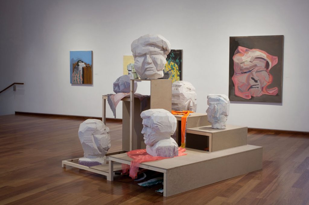 Jason Duda. Installation view of A hall of unflattering portraits depicting 2D and 3D artwork.