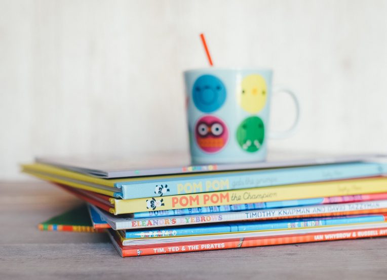 child's cup on a stack of children's books