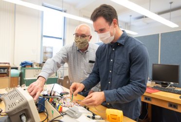 Dr. George Rutherford (left) and Zach Mobille '19 working with their electronic circuit.
