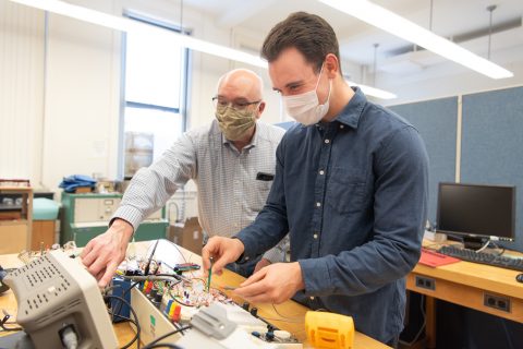 Dr. George Rutherford (left) and Zach Mobille '19 working with their electronic circuit.