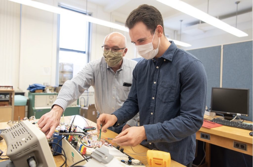 Associate Professor of Physics Dr. George Rutherford and Zach Mobille work with their electronic circuit.