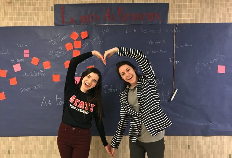Two people making a heart out of their arms