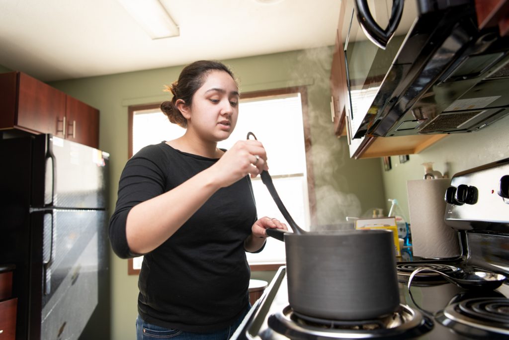Julissa Navarrete makes a batch of macaroni and cheese at her apartment to portion out for meals for the next few days.