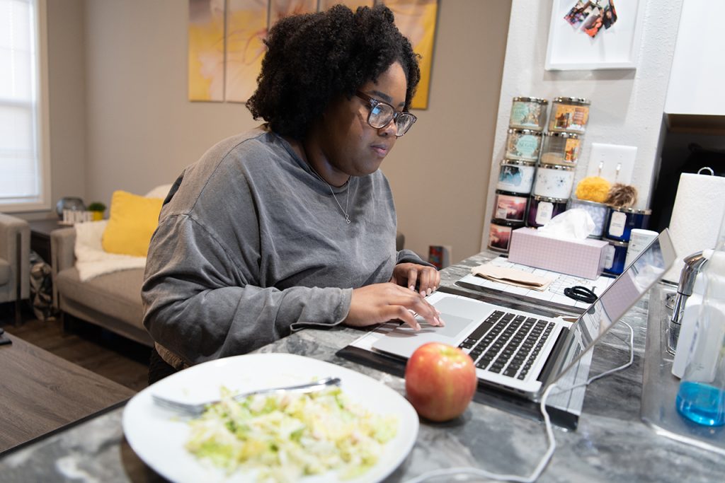 Lauren Harris reads over notes for the upcoming Student Government Association meetings while having an apple and salad for dinner.