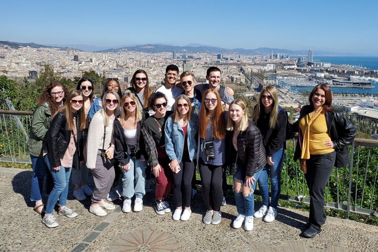 Dr. Rivadeneyra and fifteen students pose by the sea during their Spring 2021 study abroad in Spain.