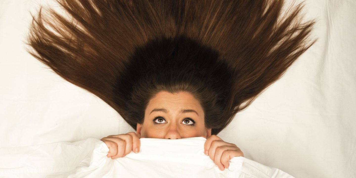 Redbird Scholar Fall 2016 cover textless with woman under bed sheets looking scared with hair stretching above her head