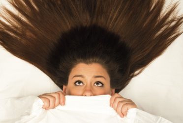 Redbird Scholar Fall 2016 cover textless with woman under bed sheets looking scared with hair stretching above her head