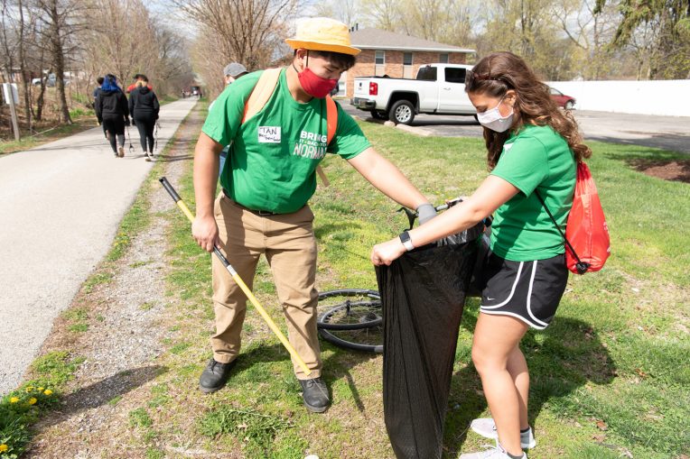 students picking up trash and putting it in a garbage bag