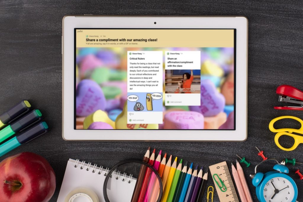 A tablet showing Padlet surrounded by art supplies