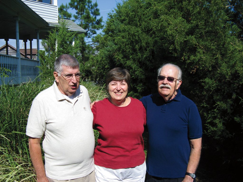 Siblings David, Charlotte, and Fred Roberts smile for a photo.