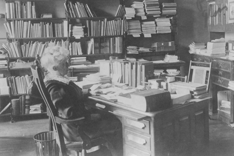 Black and white photograph of Angeline (Ange) V. Milner, first librarian at Illinois State Normal University. Milner is shown sitting at her office desk. Date unknown.