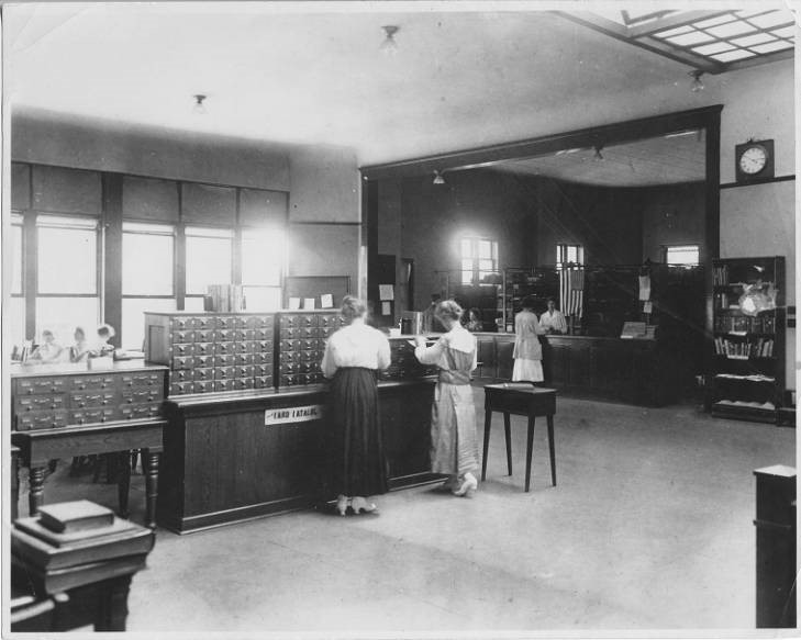 A black and white photograph of students using the card catalog when the library was located in North Hall