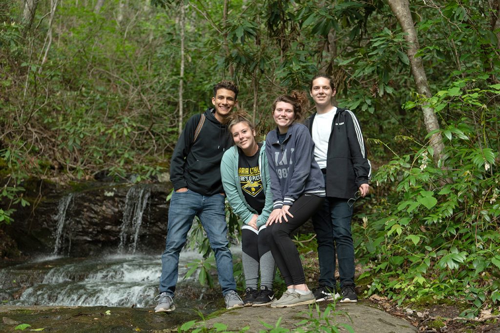 Victor Ventura (left), Anna Raymond, Katie Dowling, and William Restis pose next to a waterfall on the mountain in the woods that was adjacent to the house where they stayed at for the week in Elizabethton. They took a hike after work one day to explore the beauty that is east Tennessee.