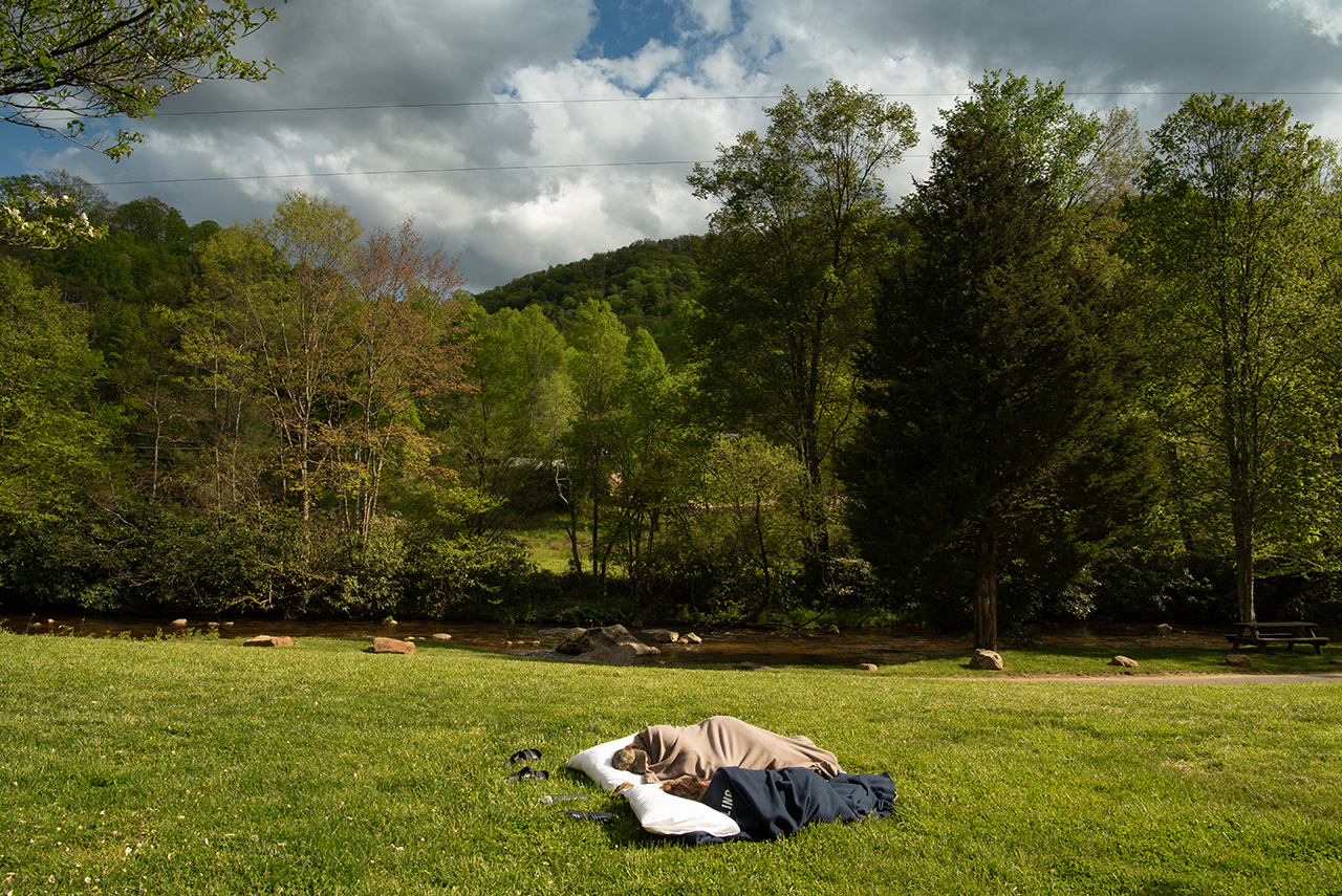 Tired from a long day of work, Anna Raymond and Katie Dowling take a nap in the front yard of the house on the mountain.