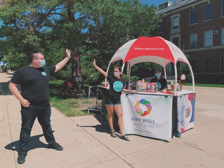 Leaders of Students Ending Rape Culture (SERC) high-five each other on the Illinois State Quad.