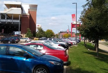 Row of cars in parking lot G73 in front of Hancock Stadium