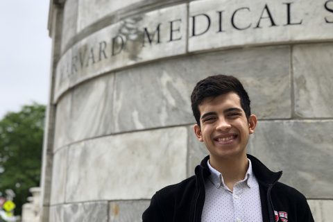 Basheer Becerra stands in front of Harvard Medical School sign.