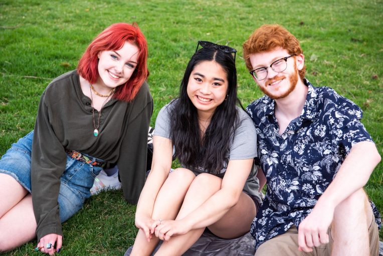 Three students enjoy some time on the Quad
