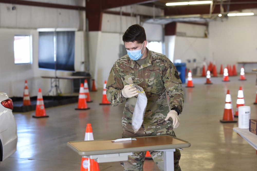 Nicholas Hensley, a medical technician with the 182nd Medical Group, processes a nasal test swab from an individual tested for COVID-19 at the McLean County Fair Grounds test site in April 2020. 