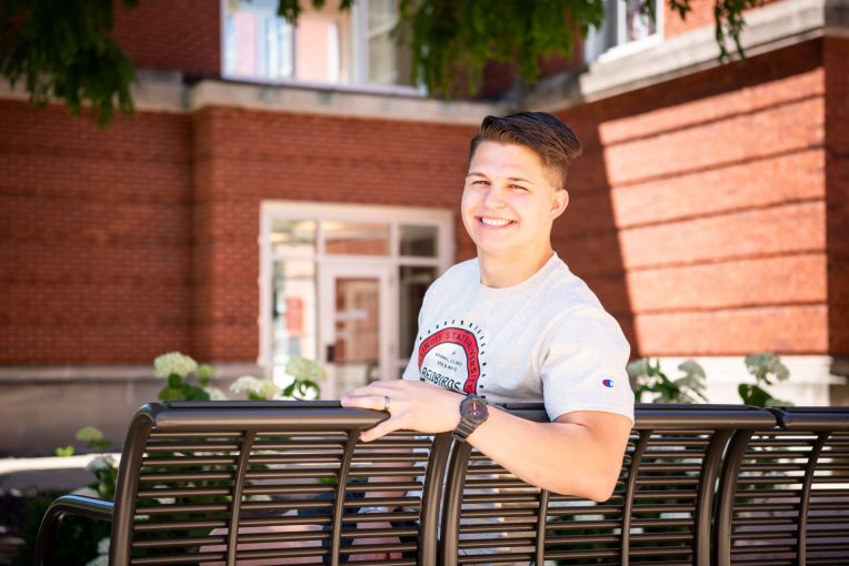 Male student sitting on a bench