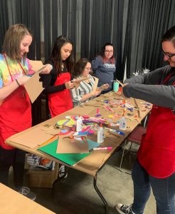 individuals doing craft projects at a table