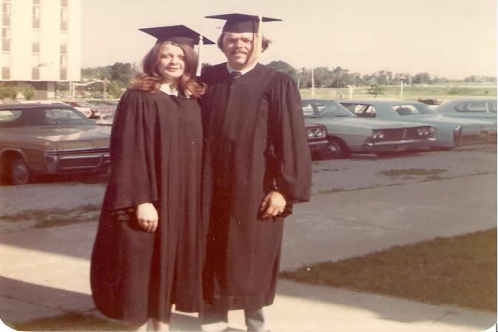 A man and a woman in graduation gowns. 