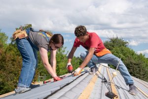 Two students working on a roof