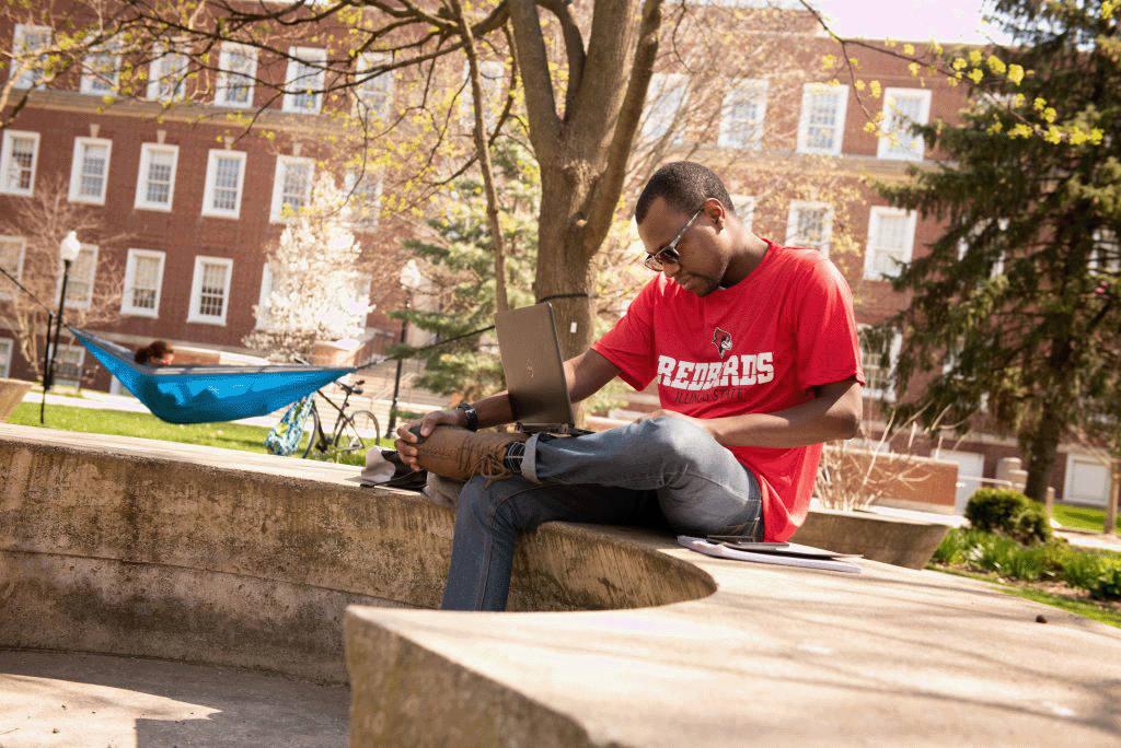 Student using laptop outside on the Quad.