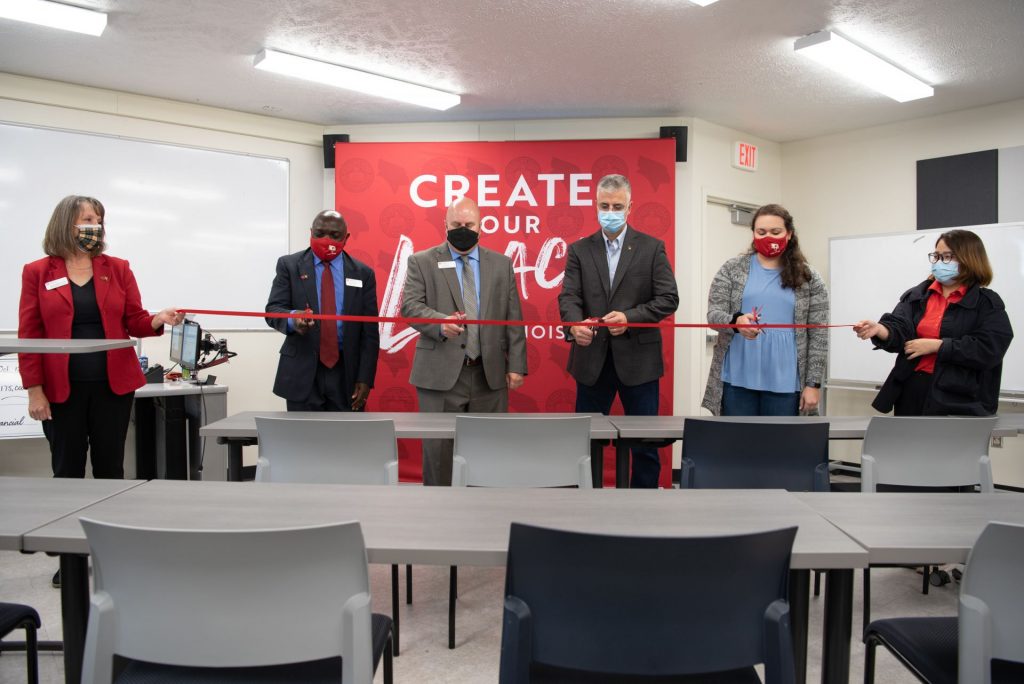 People cutting a ribbon at a grand opening.