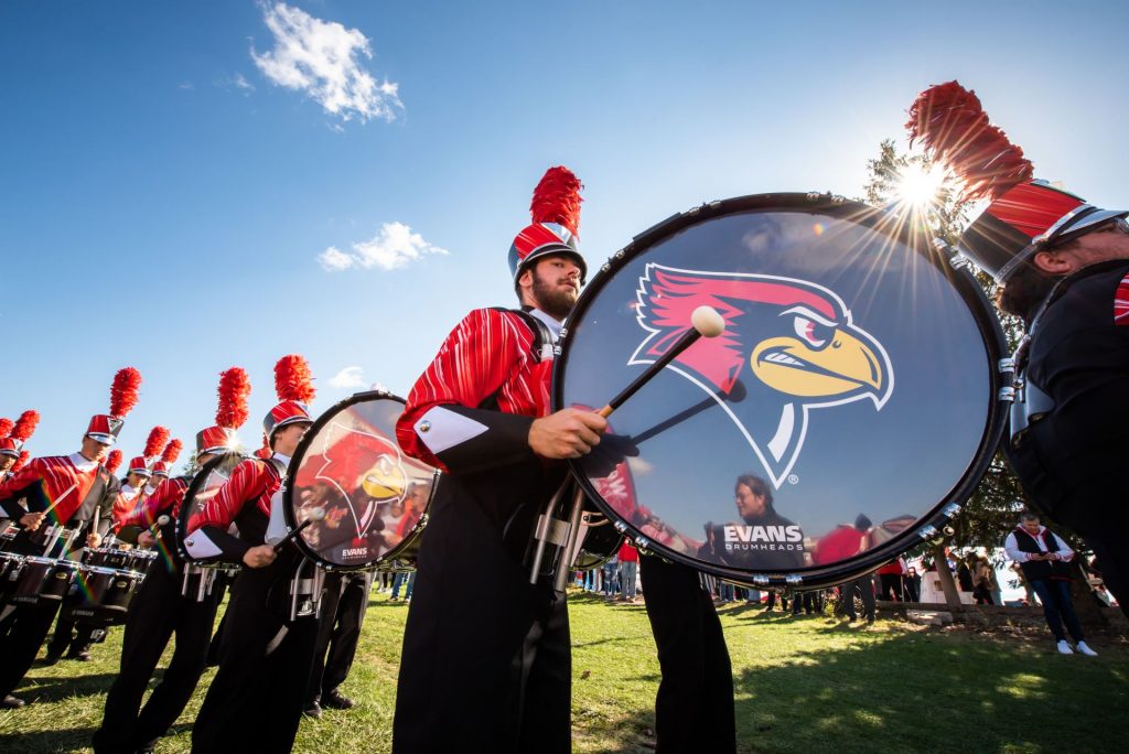 Photo of a band student performing at a Homecoming game. 