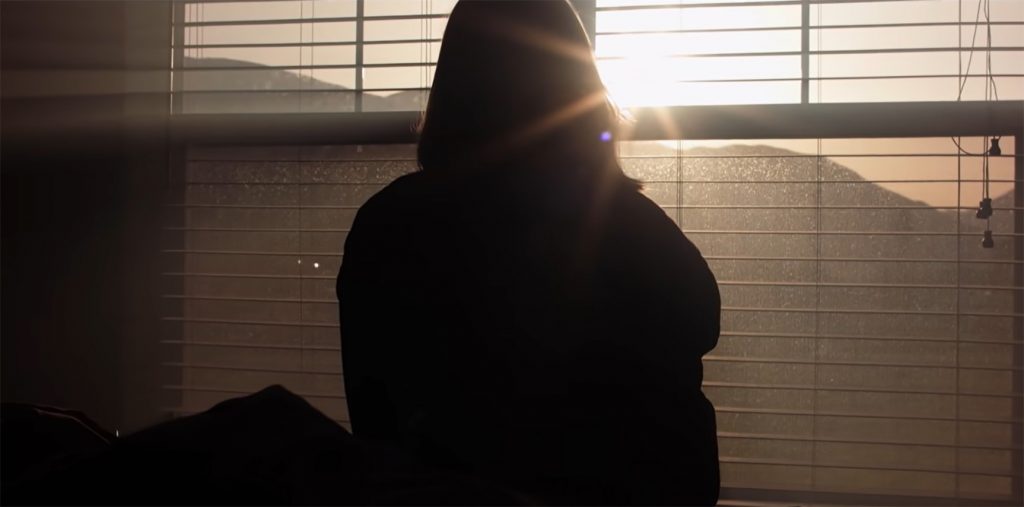 silhouette of person sitting in front of a window
