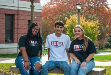 three students seated and wearing shorts that read EDI ISU (EDI is you)
