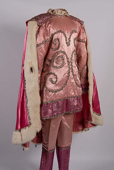 A regal pink circus wadrobe outfit consisting of pants, a top, and cape adorned with sequins. 