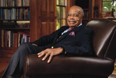 Distinguished Alum Donald McHenry ’57 sitting in a recliner in an office