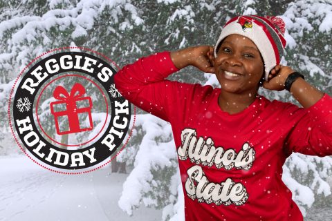 Student standing in wintery snow scene wearing winter hat with ISU Reggie head logo