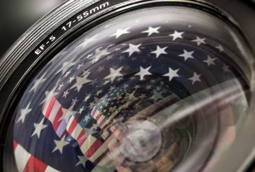 Illinois State alumni magazine cover summer 2016 showing a camera lens with the U.S. flag reflection