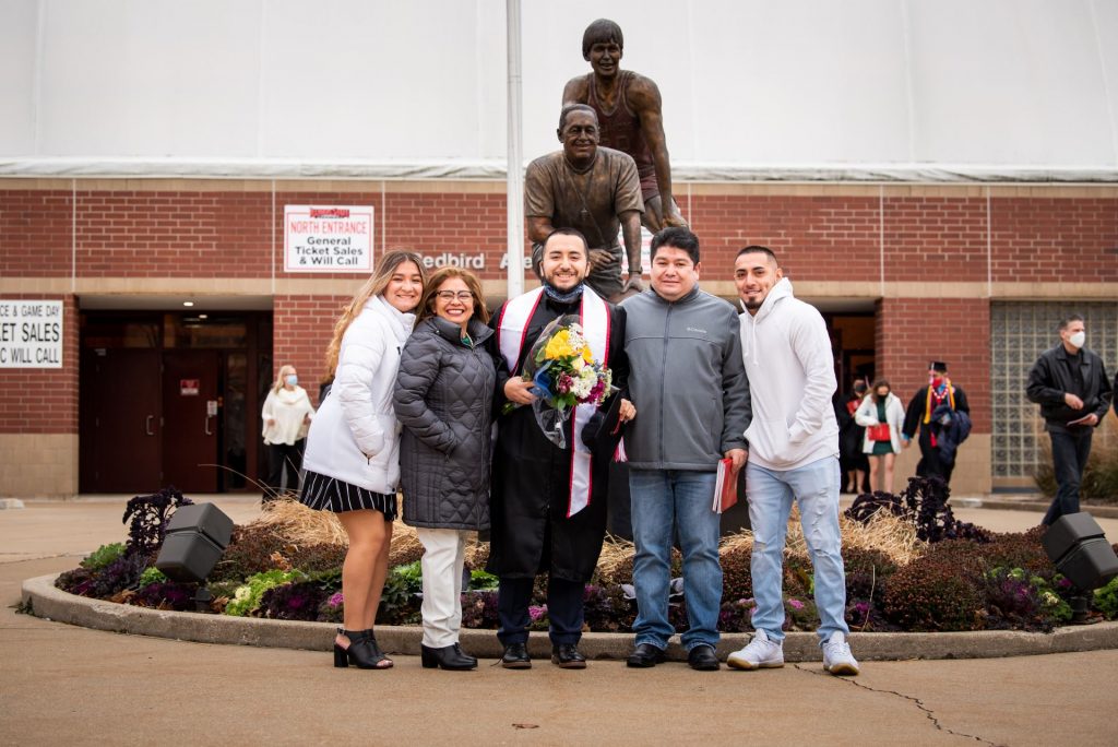 A student poses with their family after commencement.