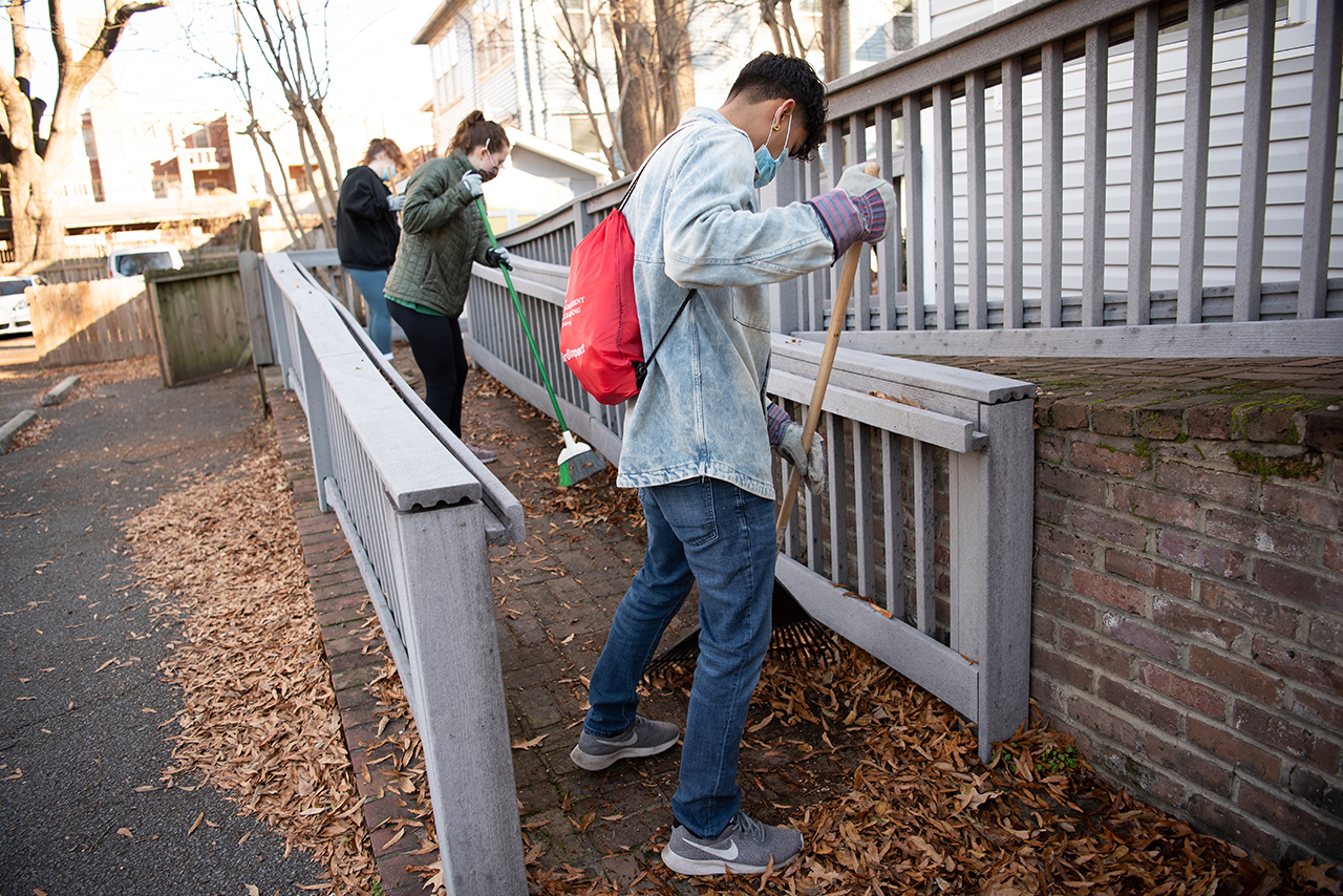 Victor Ventura, foreground, rakes leaves off of a ramp that leads to one of the homes a Hope House.